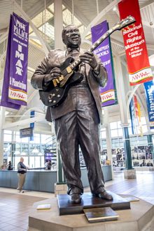 Statue of B.B. King playing an electric guitar at downtown Memphis welcome center.