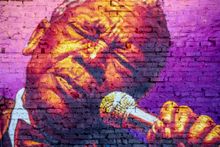 A vibrant Memphis mural of a B.B. King singing into a microphone.