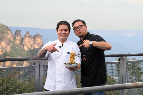 Jonathan Poh (left) and Junda Khoo with their Flying Noodles dish at Scenic World with Three Sisters in background 