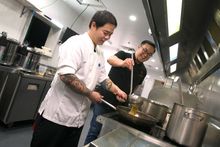 Jonathan Poh (front) and Junda Khoo cooking with their Flying Noodles dish at Scenic World 