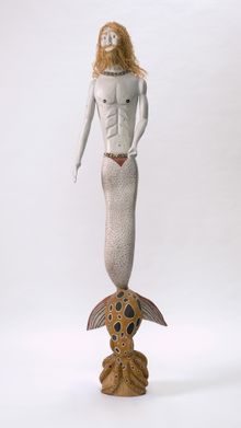 Guykuḏa Munuŋgurr 'Merman' 2016, natural pigments, shells, shark vertebra and kurrajong bark on wood, 199 x 38 x 30 cm, Art Gallery of New South Wales, Sydney, purchased with funds provided by the Aboriginal Art Collection Benefactors 2020 