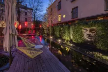 Nala Individuell Hotel: A cosy outdoor seating area with a red table and cushioned chairs.