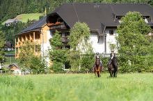 Trattlerhof Bad Kleinkirchheim: Two people on horsebacks in front of the hotel.