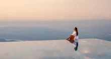 Mountain Resort Feuerberg: A woman sitting on the edge of the infinity pool at sunset. 