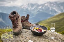 A pair of durable brown hiking boots on a rock next to a Kaiserschmarren.