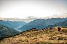 A panoramic shot of eight hikers in an alpine setting in St. Anton am Arlberg. 