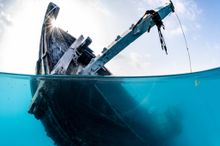 A sunken wreck in clear turquoise water makes for an exciting dive from Kandooma.