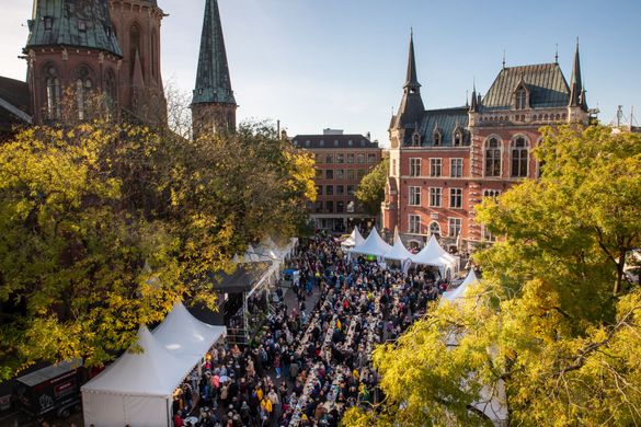 A bustling marketplace with numerous white tents and stalls  for the “Hallo Grünkohl” event.