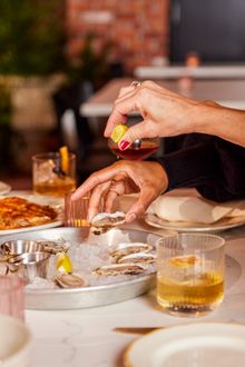 People enjoy a plate of oysters at Seraphine, a Louisanna-style restaurant.