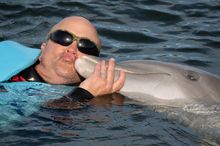 U.S. Navy Petty Officer First Class Jerry Wayne Padgett II enjoys a smooch with a dolphin at Dolphin Research Center Sunday, Jan. 11, 2026, in Marathon, Fla. Padgett was among more than 40 wounded military personnel who participated in Soldier Ride, a Sou