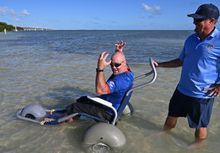 U.S. Navy Petty Officer First Class Jerry Padget, left, who was injured in 2006 while on patrol in Afghanistan, enjoys a dip in the Atlantic Ocean off Little Duck Key, Fla., after completing an adaptive bicycle ride on the Florida Keys’ Seven Mile Bridge 
