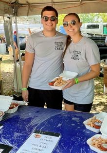 Volunteers serve cold Key West pink peel-and-eat shrimp at one of the many food booths during the 2025 Florida Keys Seafood Festival at Truman Waterfront Park in Key West. The shrimp stand was part of the event’s wide selection of fresh, locally caught se