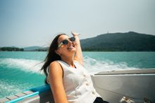 Summer in Austria: A woman in the back of a boat on a lake. 