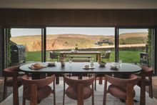 A dining table is elegantly placed before expansive sliding doors that unveil a scene of total tranquillity