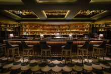 300 over illuminated bottles become the dramatic backdrop against which the bartenders perform.