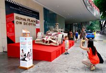 Guest taking photo of her child with seashells race car, Royal Plaza on Scotts
