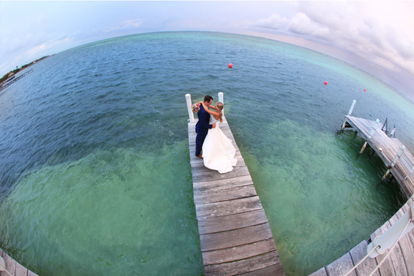 A newlywed couple enjoys a romantic moment post ceremony on the dock at Ambergris Caye's Las Terrazas Resort & Residences.