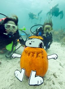Jana Vandelaar, left, and her daughter Jacqueline Vandelaar, right, show off their Snoopy jack-o-lantern created with a vote mes