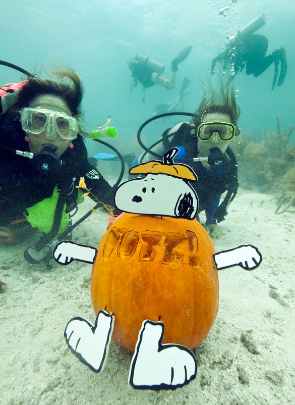Jana Vandelaar, left, and her daughter Jacqueline Vandelaar, right, show off their Snoopy jack-o-lantern created with a vote mes