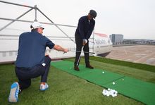 Golfer Justin Rose  coaches Ian Wright to play a shot from the wing of a British Airways Boeing 747