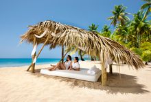 Guests unwind beneath a shaded palapa on the stunning beach at Sublime Samana