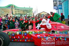 Santa zooms into the world's largest children's museum in a race car!