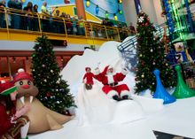 Santa zips down the Yule Slide with a lucky child