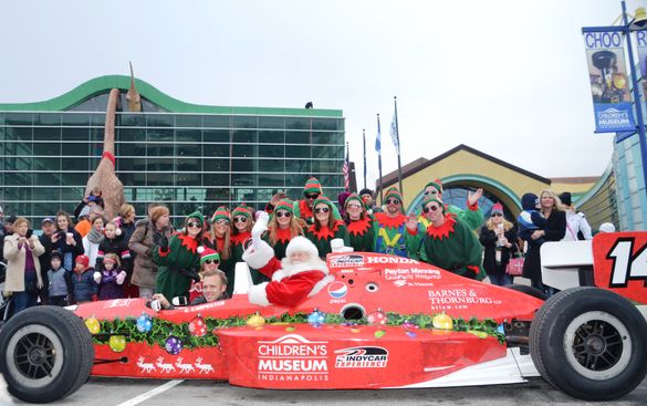 Santa races in to world's largest children's museum in an Indy Racing Experience two-seater driven by Ed Carpenter.