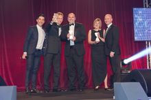 Karen Jones, Director, receiving the award on stage from sponsor Matt Murphy and comedian, Russell Kane.