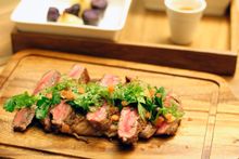 Grilled M4 Wagyu beef striploin with gratin potatoes, picked herbs and ginger-garlic sauce