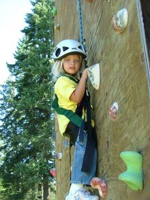 Young girl on climbing wall, Red Horse Mountain Guest Ranch, Idaho