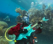 Mike Limerick pretends to play a mock musical instrument at the Lower Keys Underwater Music Festival Saturday, July 12, 2014, in