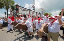 Ernest Hemingway look-alikes turn in front of Sloppy Joe's Bar during the Running of the Bulls Saturday, July 19, 2014, in Key W
