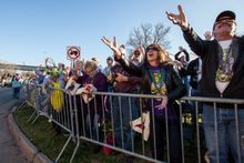 Attendees at the 9th Annual Red River Mardi Gras Bash reach for beads as the parade passes.