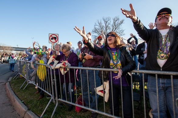 Attendees at the 9th Annual Red River Mardi Gras Bash reach for beads as the parade passes.