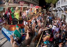 A float and revelers proceed down Duval Street during the Fantasy Fest Parade Saturday, Oct. 25, 2014, in Key West, Fla. The par