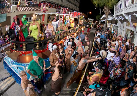 A float and revelers proceed down Duval Street during the Fantasy Fest Parade Saturday, Oct. 25, 2014, in Key West, Fla. The par