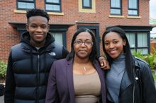 Jordan, Elaine and Courtney Harrison outside their new home at Woodhouse Park. 