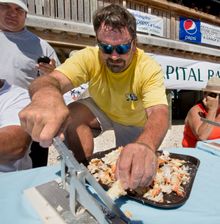 Larry Smorgala cracks stone crab claws on his way to taking top honors in the individual category at the Keys Fisheries Stone Cr
