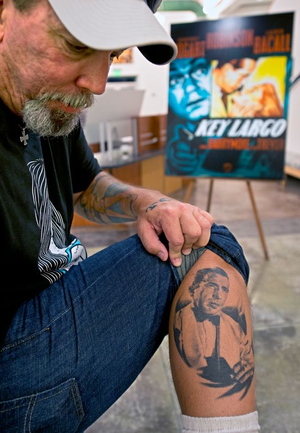 In this Thursday, May 2, 2013, photo released by the Florida Keys News Bureau, Brad Davis show his right leg calf tattoo of lege