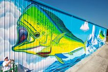 Artist David Dunleavy clears his paint spray gun nozzle while putting finishing touches on a huge mural entitled 