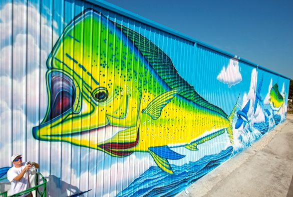 Artist David Dunleavy clears his paint spray gun nozzle while putting finishing touches on a huge mural entitled 