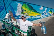 Artist David Dunleavy poses with his huge mural entitled 