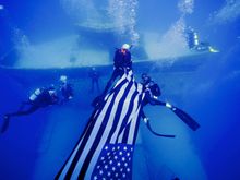 Divers deploy an American flag on the artificial reef USNS General Hoyt S. Vandenberg Sunday, May 25, 2014, about seven miles of