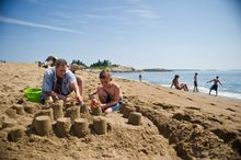 Beachgoers enjoying the sun and sand in Maine where businesses are offering special deals to Canadian visitors.