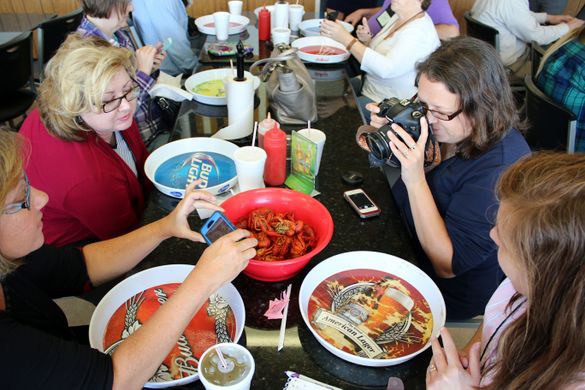 Journalists eat (and photograph) crawfish during a tour of Shreveport-Bossier in 2014.