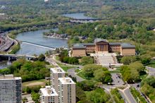 An aerial view of the Philadelphia Museum of Art with Boathouse Row and the Schuylkill River in the background.