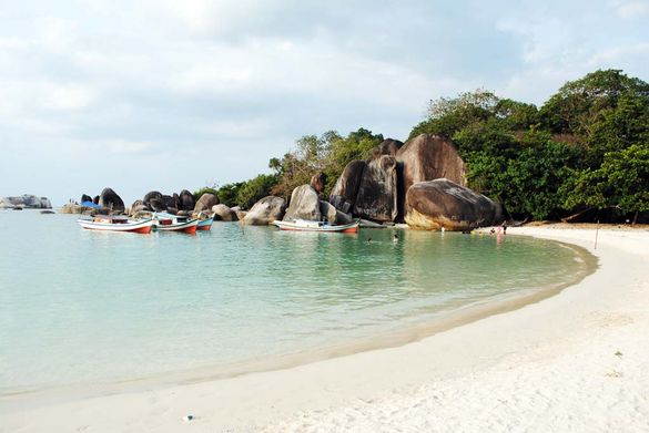 Belitung Island beach boats and swimmers at Tanjung-Tinggi