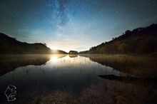 The setting moon casts a warm light over Loch Trool in the Galloway Forest Dark Sky Park, bringing out Autumn colours in the ancient Oak woodland. Overhead, the Milky Way sets into the West.