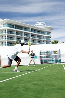 Tennis courts at Seashells Mandurah with the hotel in the background